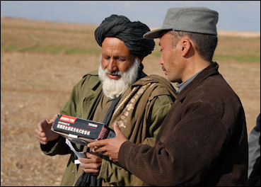 20120512-Radio_Gureshk_--_Afghan_Police_officer_hands_out_radios.jpg